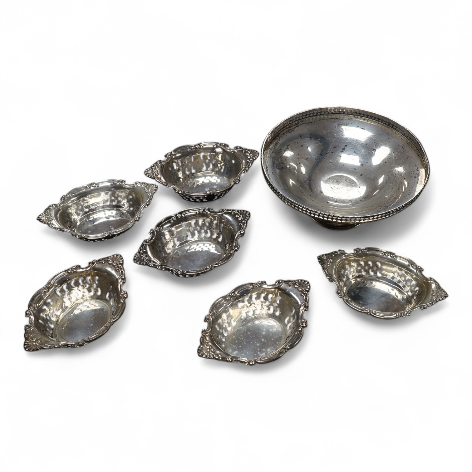 A George V silver pedestal small bowl, diameter 13.1cm, together with a set of six Canadian Birks pieced sterling nut dishes. Condition - fair